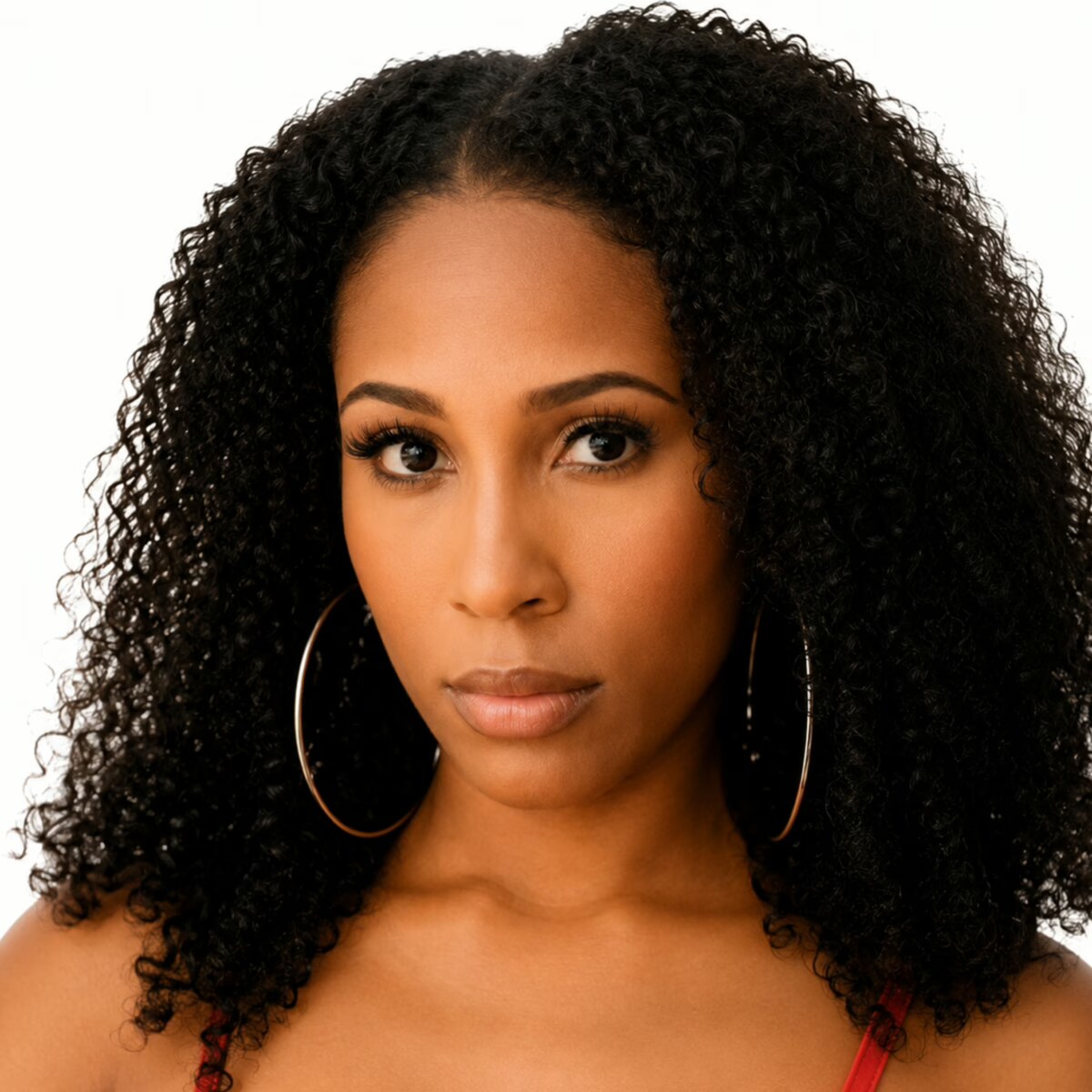 Olivia Jayy headshot with hoop earrings and curly hair